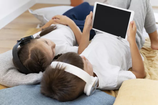two kids look at tablet together