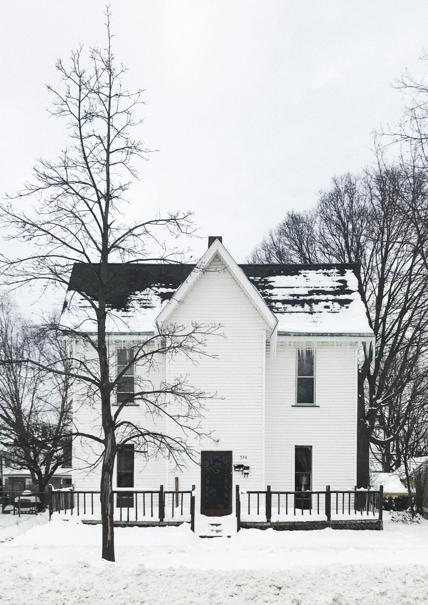 house in the snow with a small fence